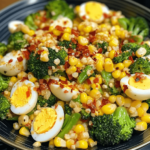 A vibrant bowl of spicy egg, broccoli, and corn salad, featuring boiled eggs, steamed broccoli, and sweet corn tossed in a spicy dressing, garnished with fresh herbs.