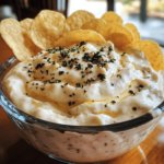 A bowl of Dunkaroo dip, a creamy and colorful dip sprinkled with rainbow confetti, surrounded by cookies and graham crackers for dipping.