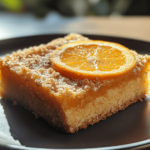 Orange & Almond Coffee Cake with a golden crumb topping, sliced to reveal its moist interior, garnished with orange slices and almond flakes.