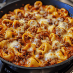 Hearty Meat Lovers Pizza Tortellini featuring cheesy tortellini, pepperoni, sausage, and bacon in a rich marinara sauce, topped with melted mozzarella and fresh herbs.