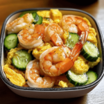 Shrimp, Egg & Cucumber Stir-Fry featuring juicy shrimp, fluffy scrambled eggs, and crisp cucumber slices, served in a bowl with a sprinkle of green onions.